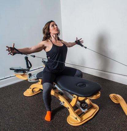 woman using GYROTONIC machine to stretch body