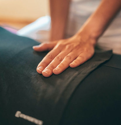 massage therapist pressing on small of client's back
