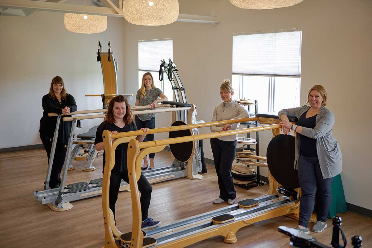 five women standing around some equipment in a physio therapy clinic