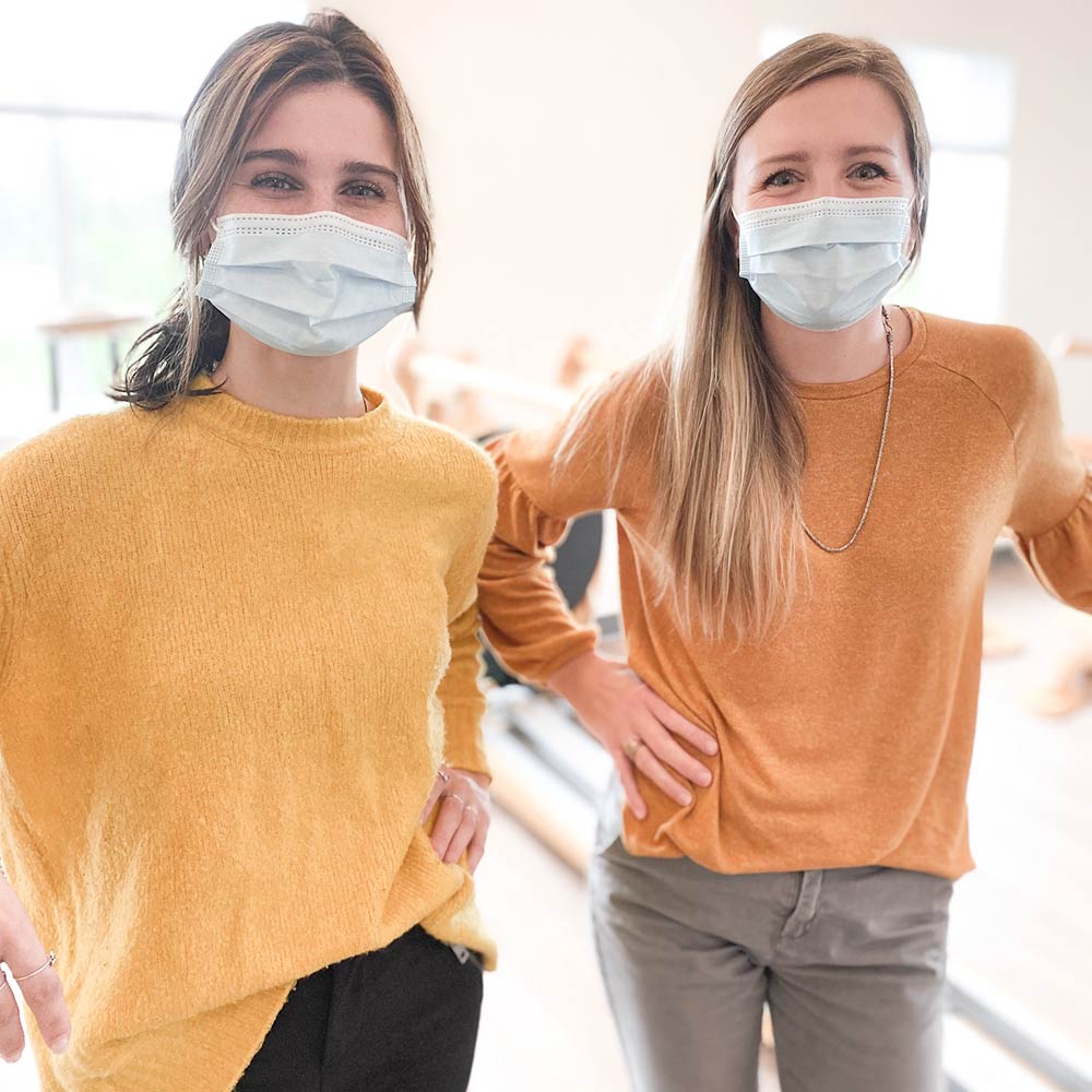 two women wearing masks