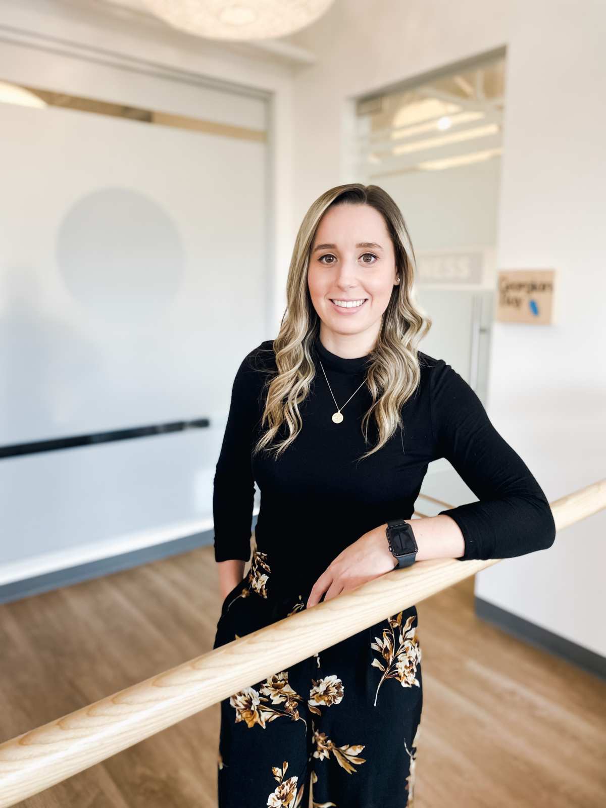 Dr. Vanessa leaning on a wooden rail