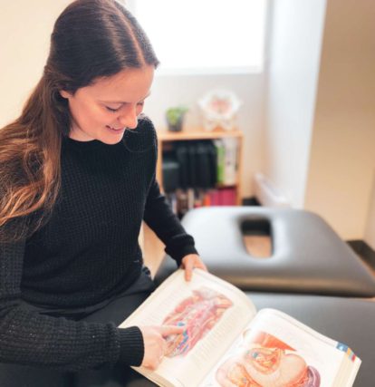 a woman sitting on a couch reading a book