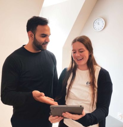 a man and a woman looking at a tablet