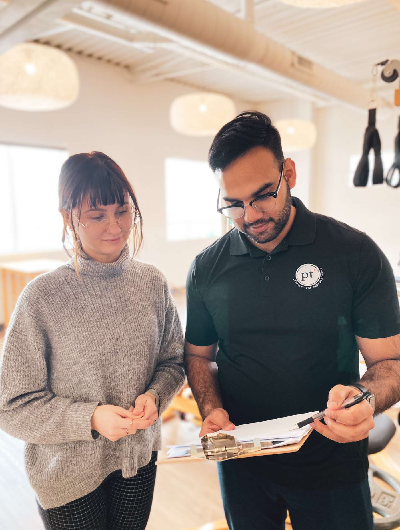 a man and a woman looking at a clipboard