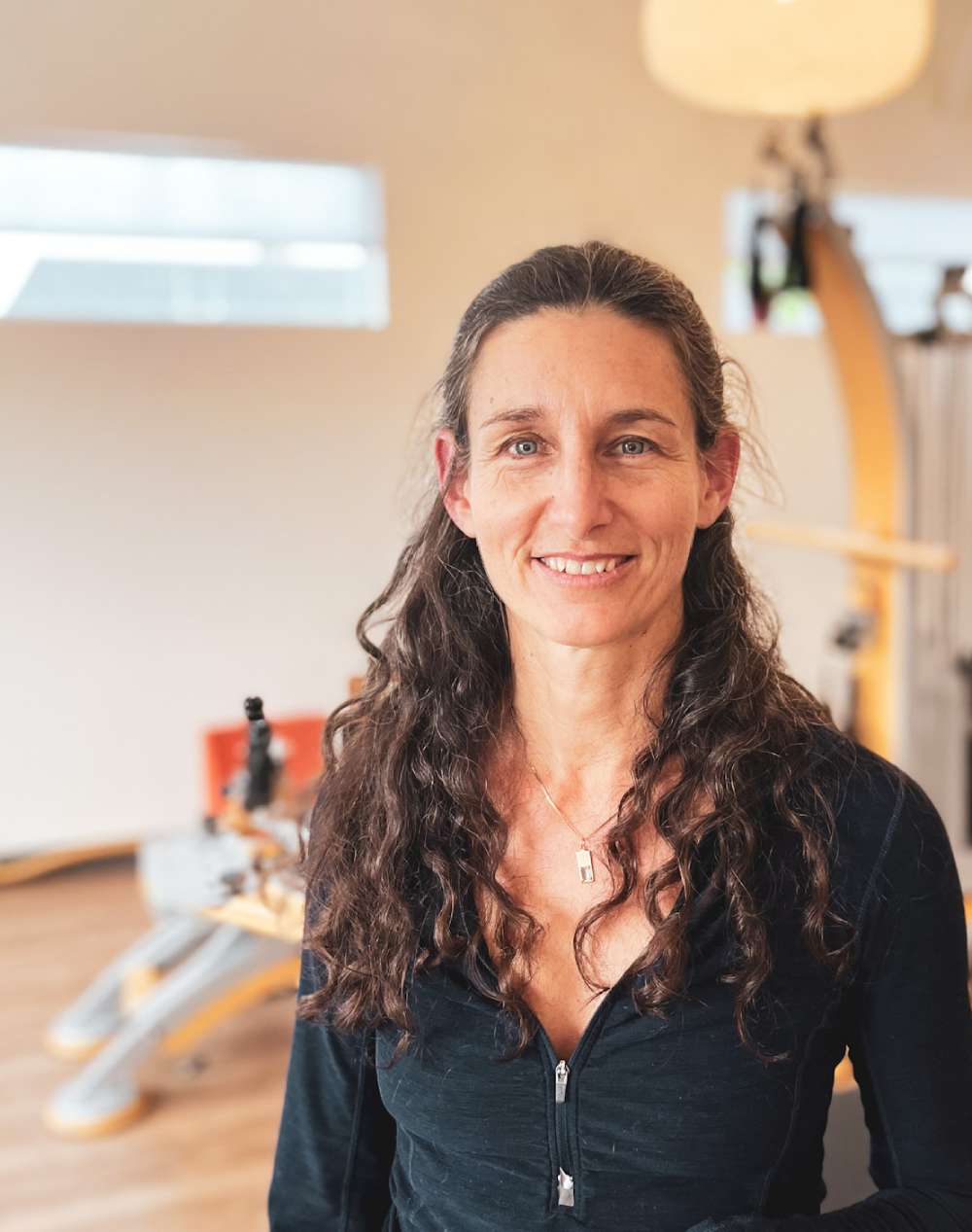 a woman with long hair standing in a gym