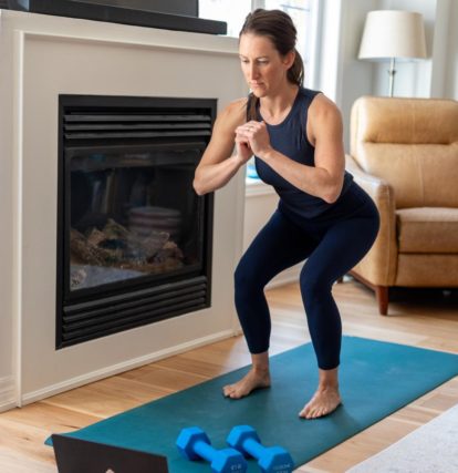 a woman doing a yoga pose in front of a fireplace