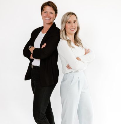 Two women standing side by side giving pose for photo