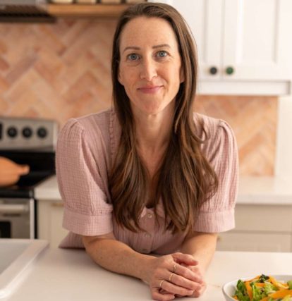 a woman leaning on a kitchen counter