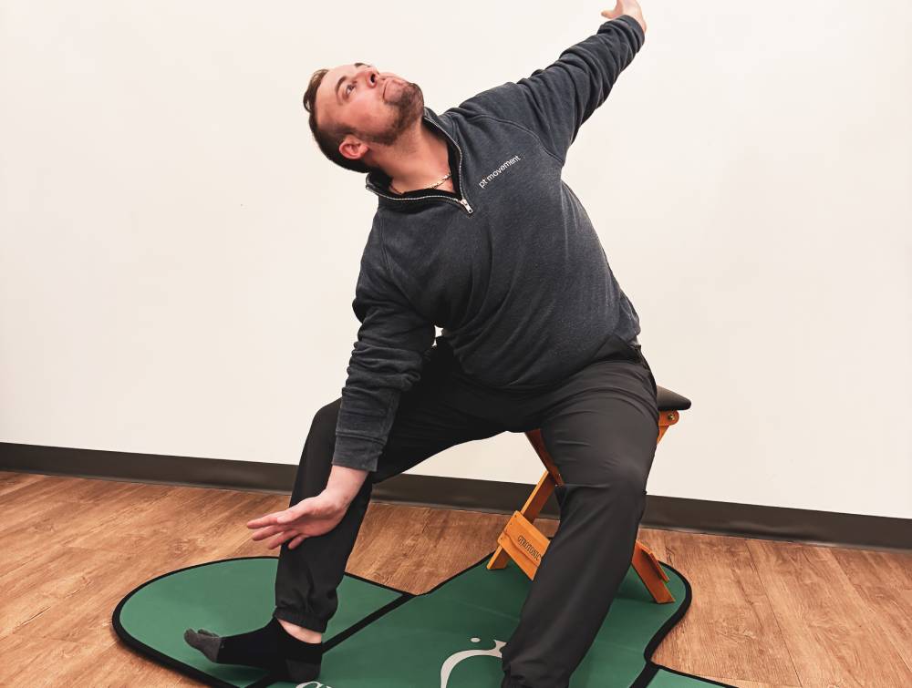 a man sitting on a stool and stretching